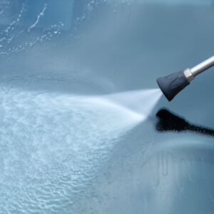 a power washer washing a window
